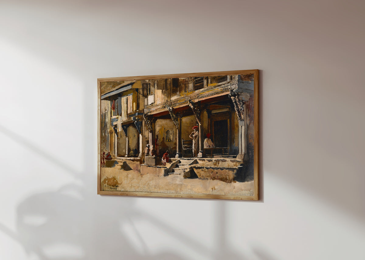Framed art print of Merchants in Bombay by Edwin Lord Weeks, in a light wood frame on a sunlit white wall, seen at a slight angle