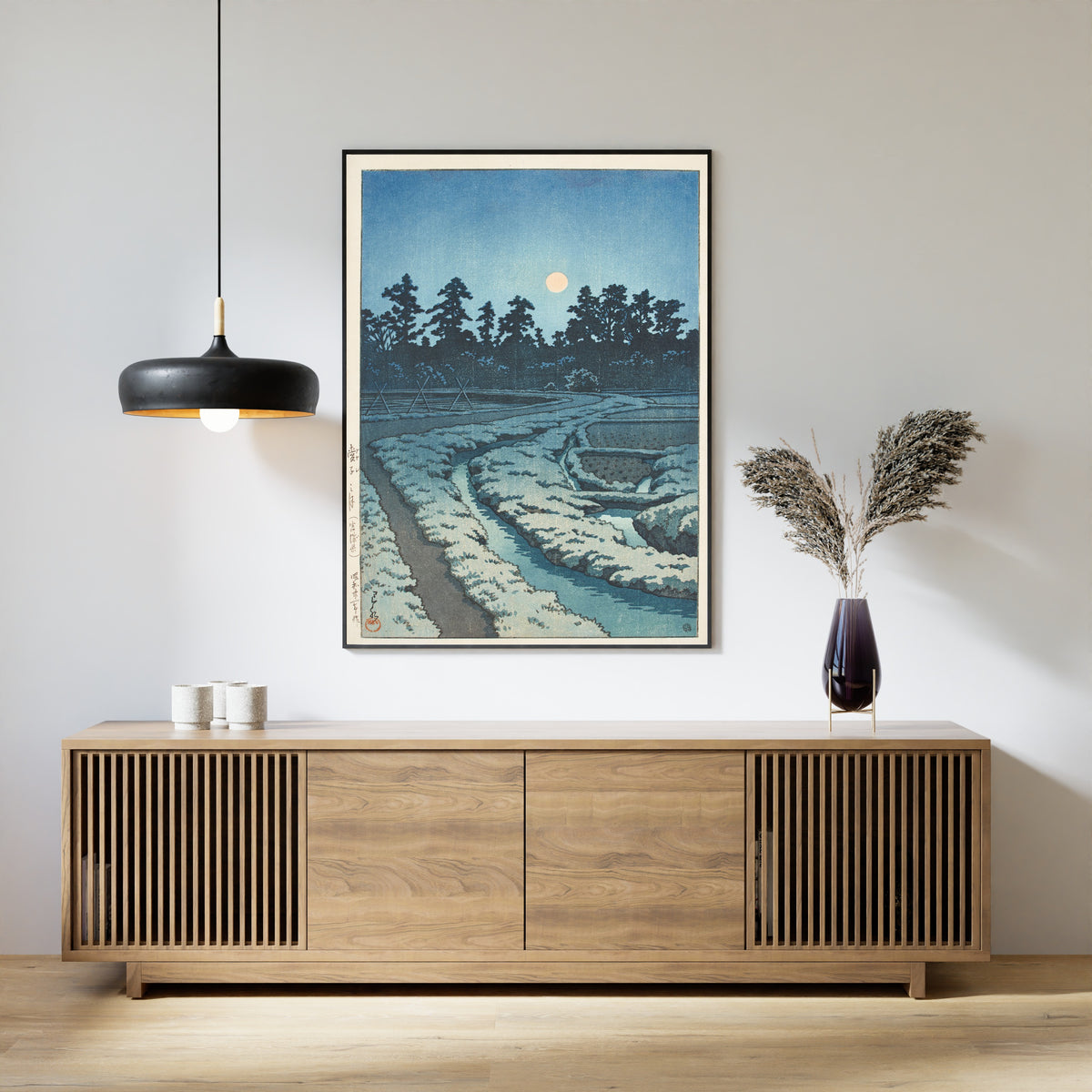 Framed art print of Moon at Ayashi, Miyagi Prefecture by Kawase Hasui, above a slatted wood sideboard