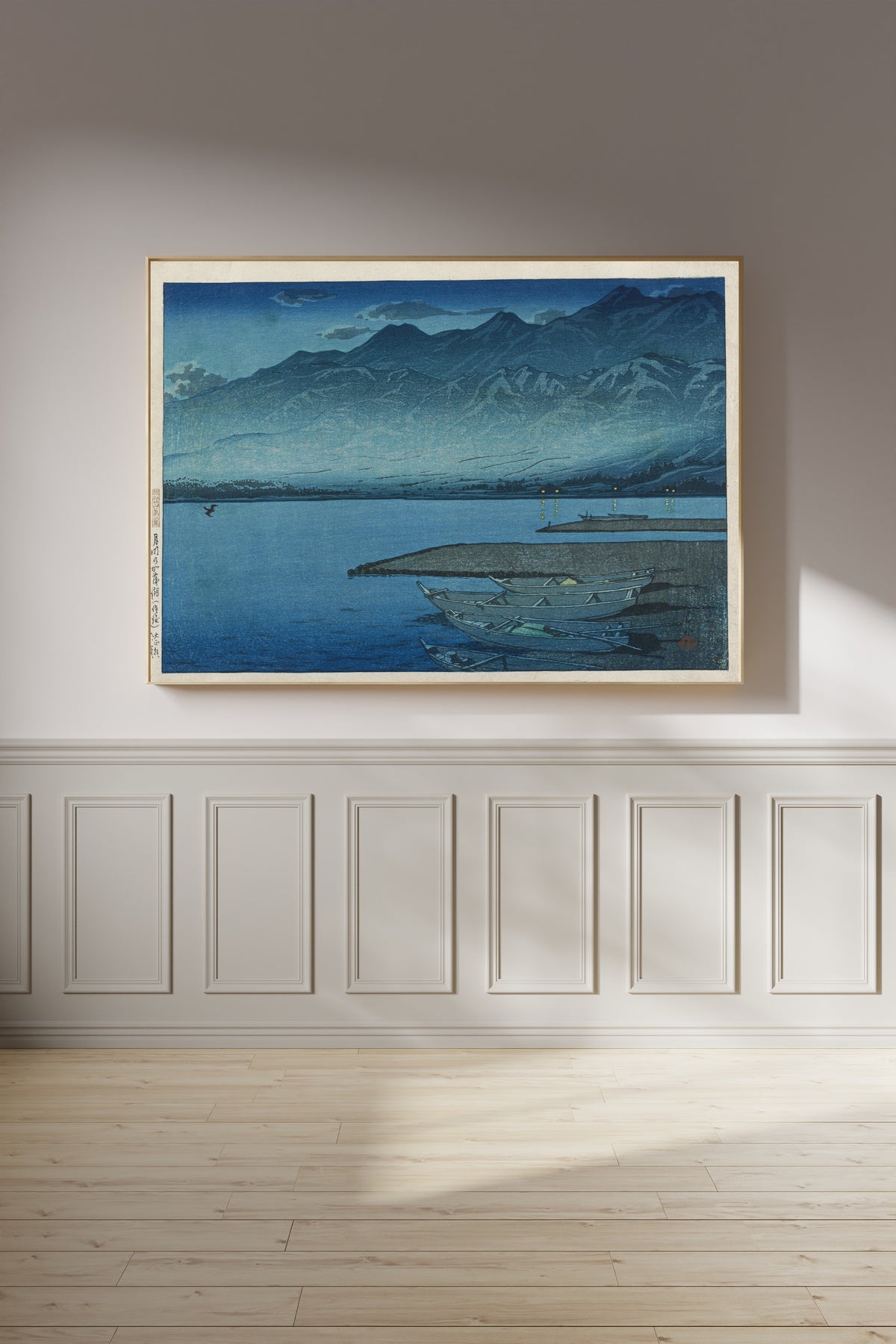 Framed art print of Moonlight over Lake Kamo, Sado by Kawase Hasui, on a panelled wall in afternoon light