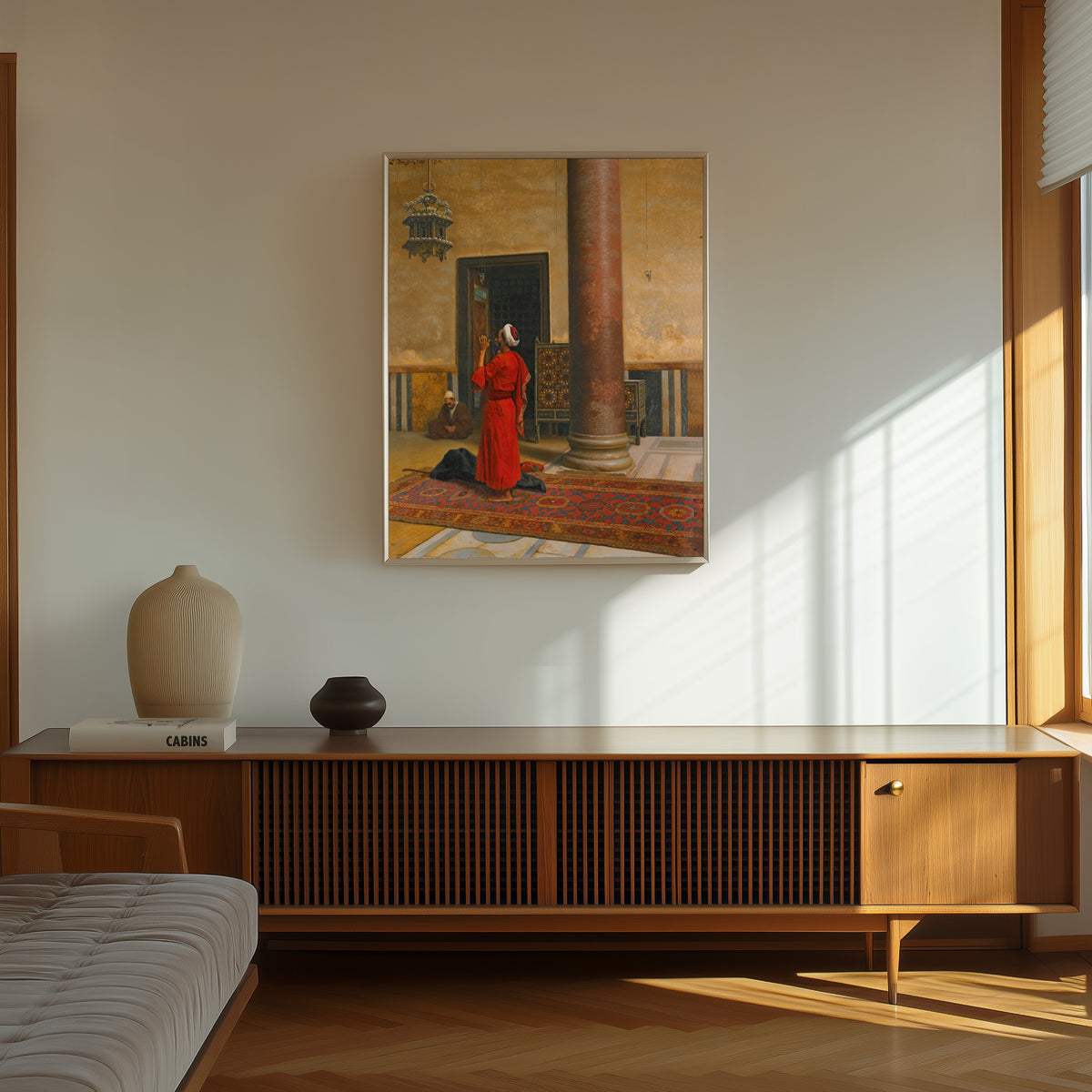 Framed art print of Morning Prayers by Ludwig Deutsch, in a thin light frame on a sunlit wall above a wooden sideboard