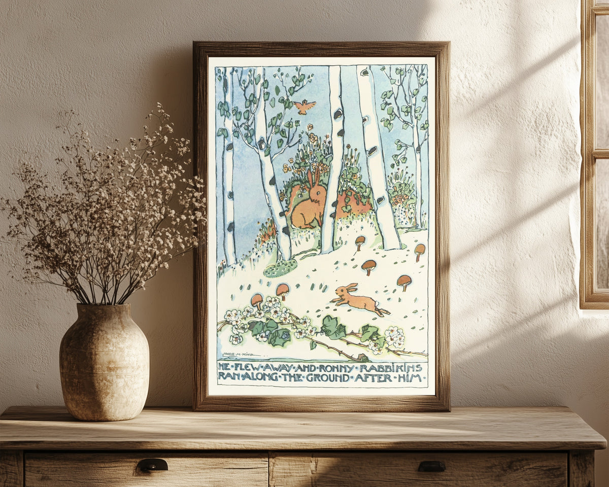 Framed art print of Mummy's Bedtime Story Book: He Flew Away and… by Jessie M. King, in a dark wood frame leaning on a rustic console beside dried flowers
