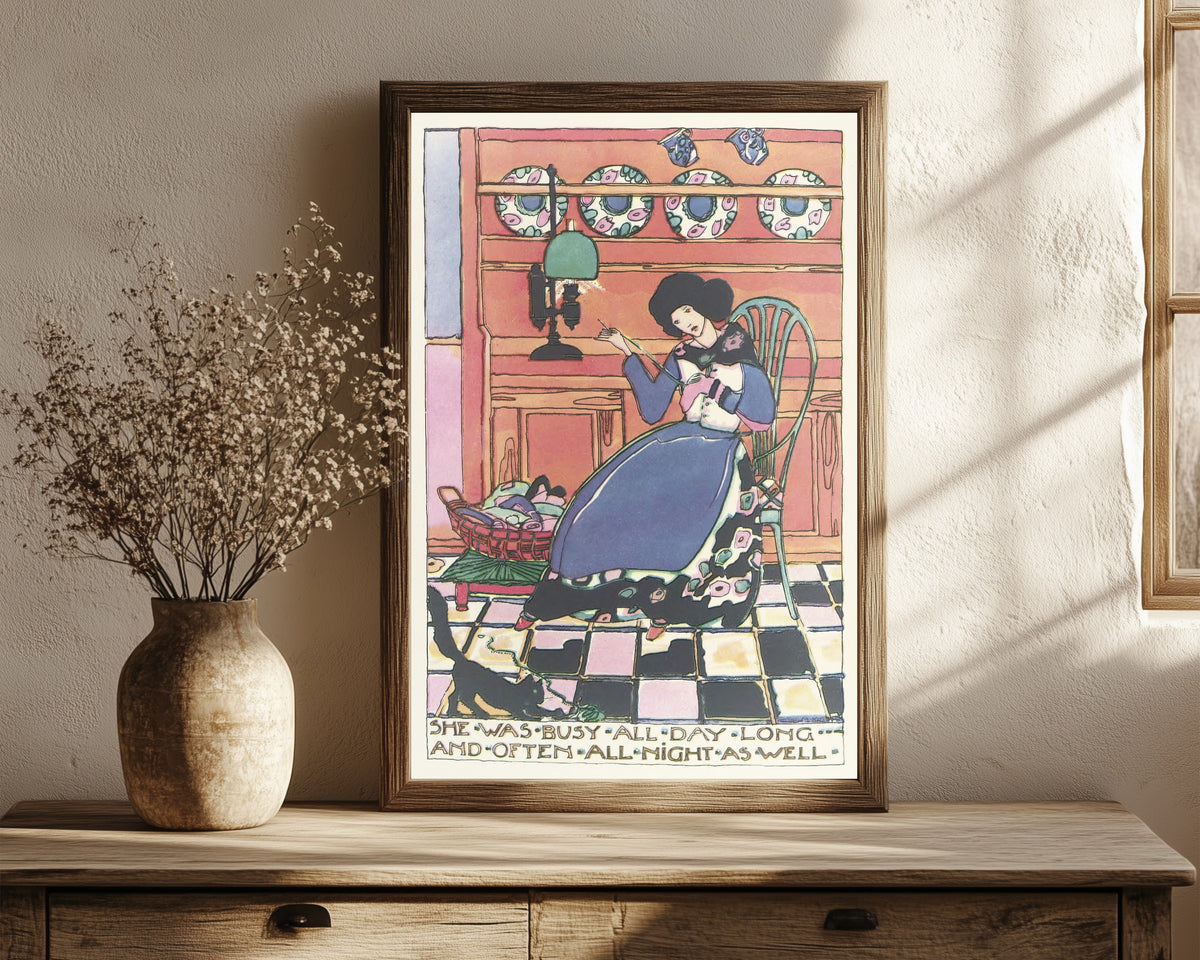 Framed art print of Mummy's Bedtime Story Book: She Was Busy All Day… by Jessie M. King, in a dark wood frame leaning on a rustic console beside dried flowers