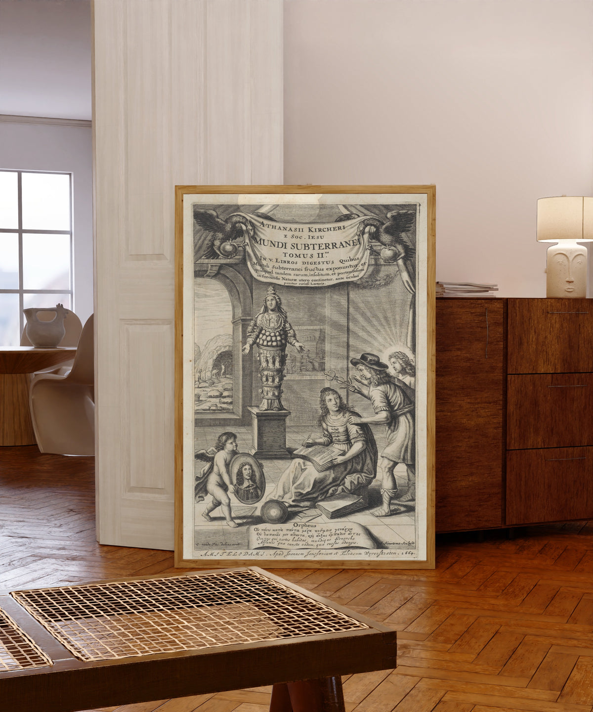 Framed art print of Mundus Subterraneus, Volume II: Title Page by Athanasius Kircher, in a light wood frame leaning in a warm room with a parquet floor