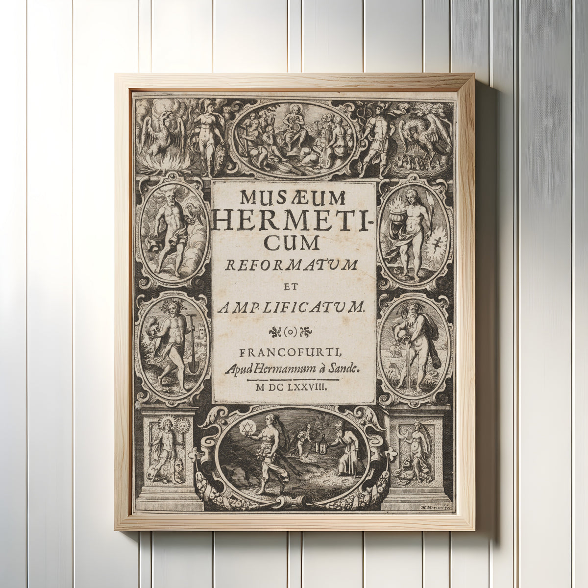 Framed art print of Musaeum Hermeticum: Engraved Title Page by Matthäus Merian, in a light wood frame on a white panelled wall