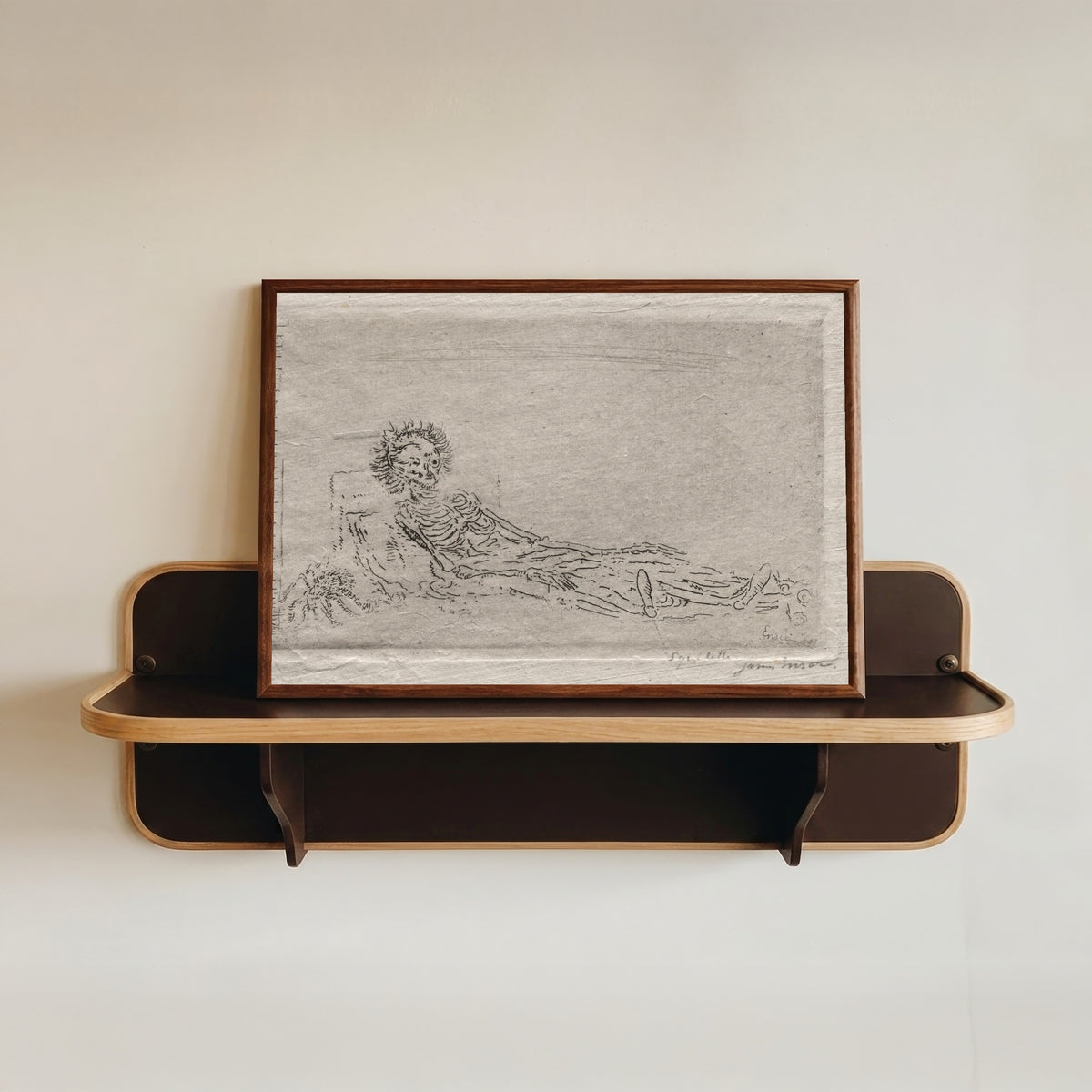 Framed art print of My Portrait in the Year 1960 by James Ensor, in a dark wood frame resting on a wall shelf