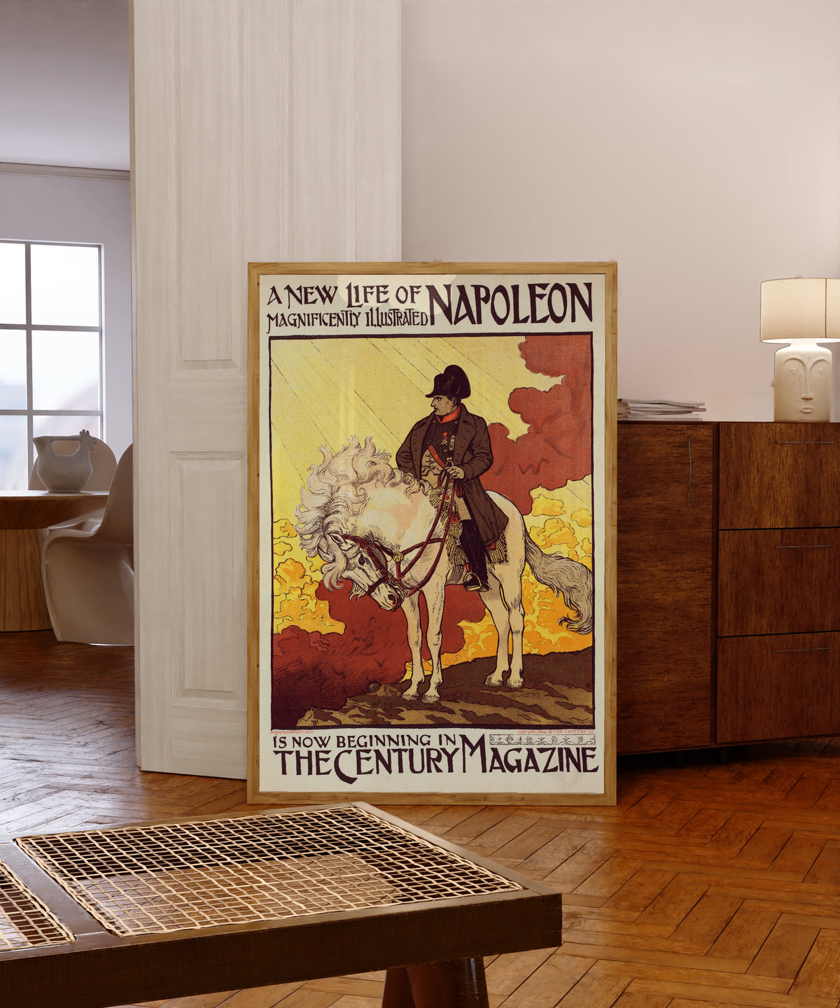 Framed art print of Napoléon by Eugène Grasset, in a light wood frame leaning in a warm room with a parquet floor