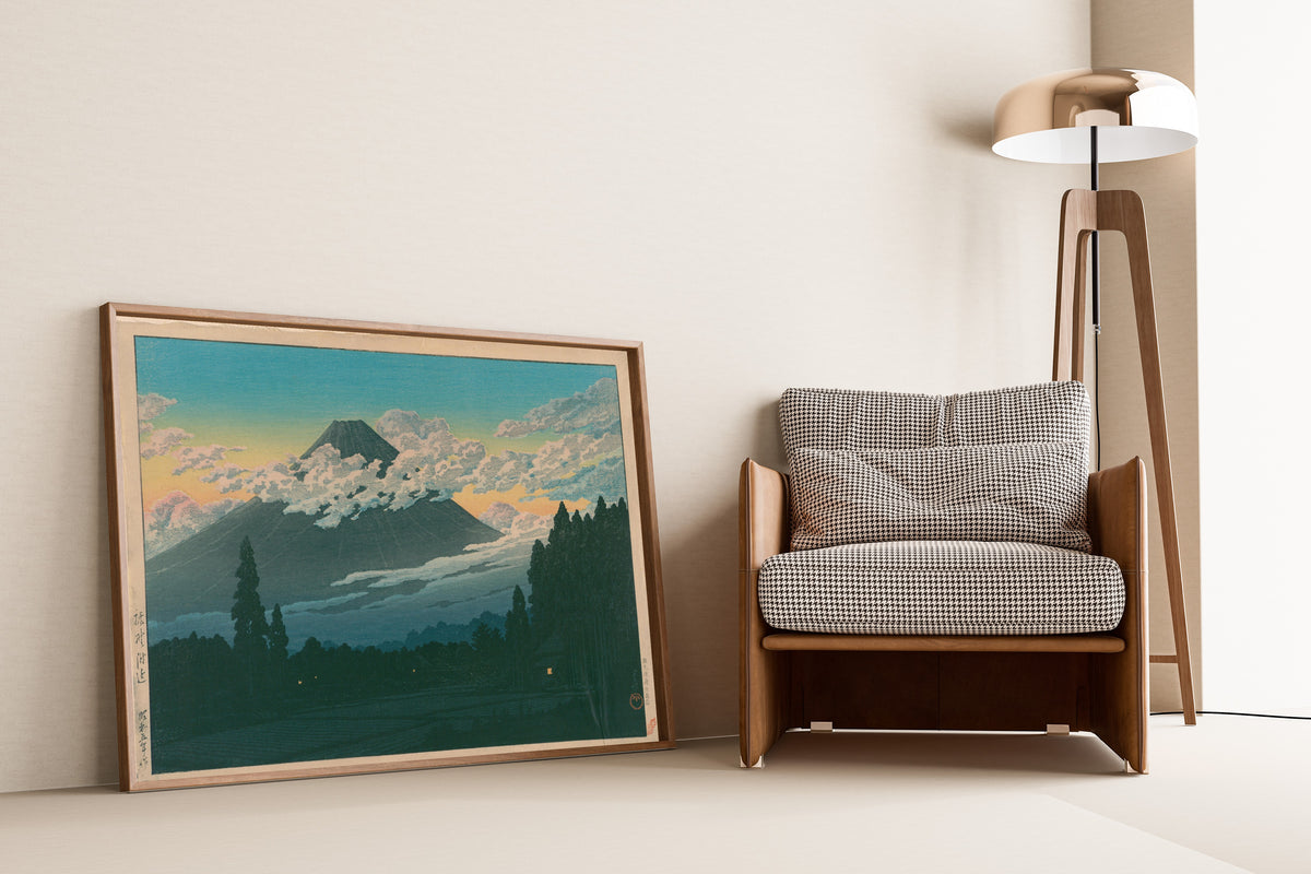 Framed art print of Near Susono by Kawase Hasui, leaning against a wall beside an armchair and a floor lamp