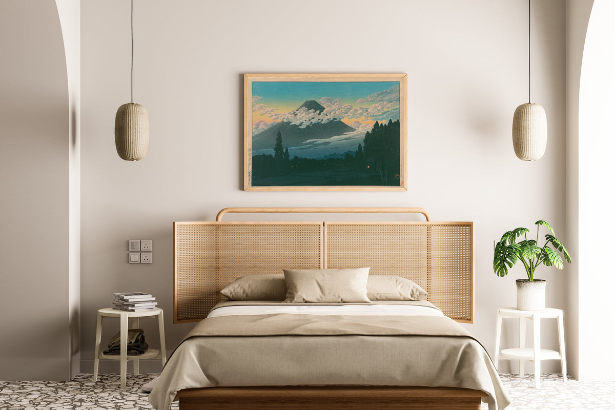 Framed art print of Near Susono by Kawase Hasui, above a cane-headboard bed