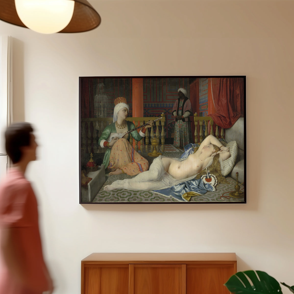 Framed art print of Odalisque with Slave by Jean-Auguste-Dominique Ingres, in a slim black frame on a warm wall in a sunlit room