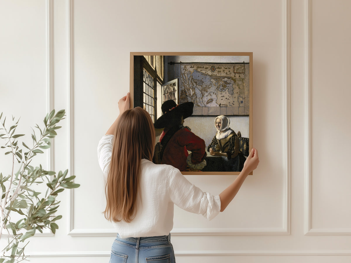 Framed art print of Officer and Laughing Girl by Johannes Vermeer, hung on a panelled wall