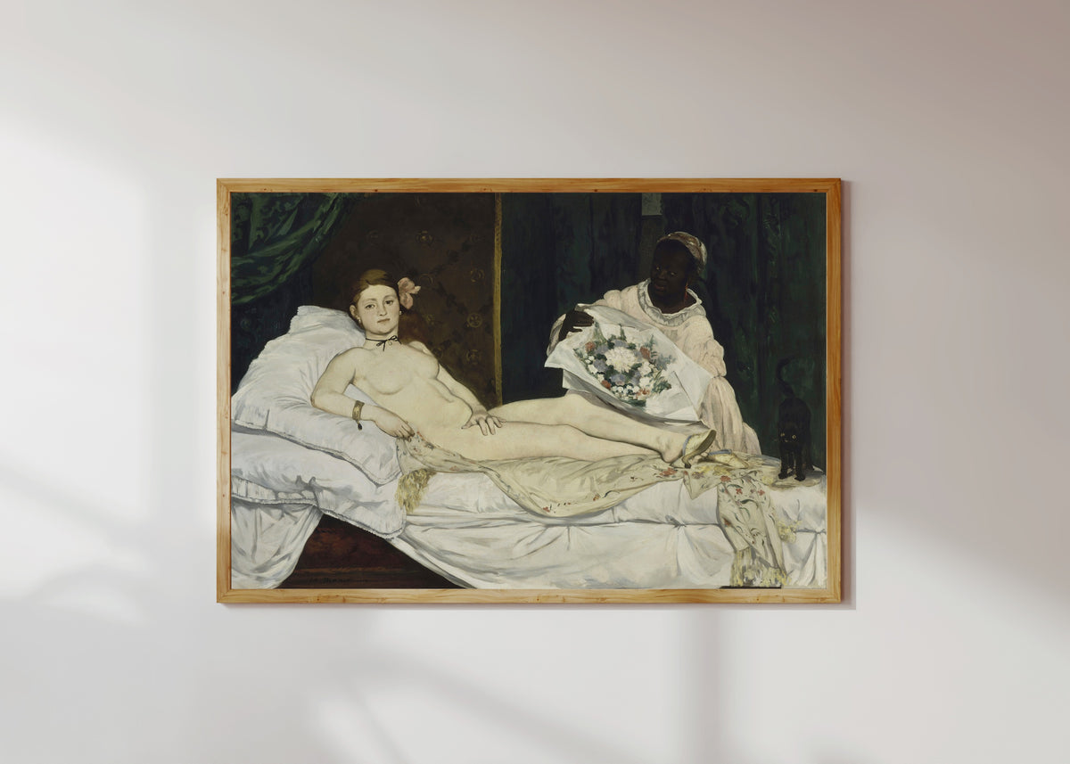 Framed art print of Olympia by Édouard Manet, in a light wood frame on a sunlit white wall