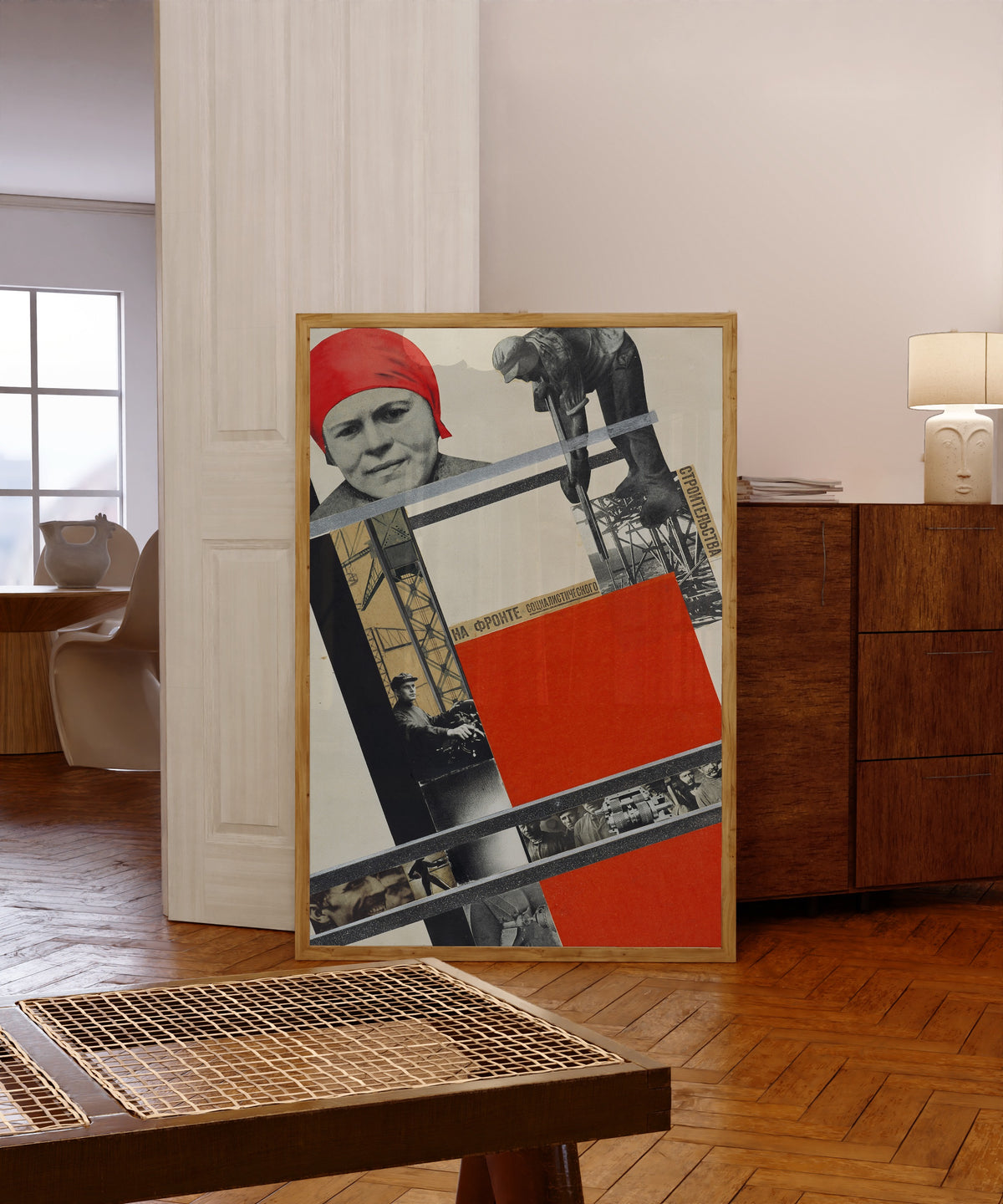 Framed art print of On the front of socialist construction by Gustav Klutsis, in a light wood frame leaning in a warm room with a parquet floor