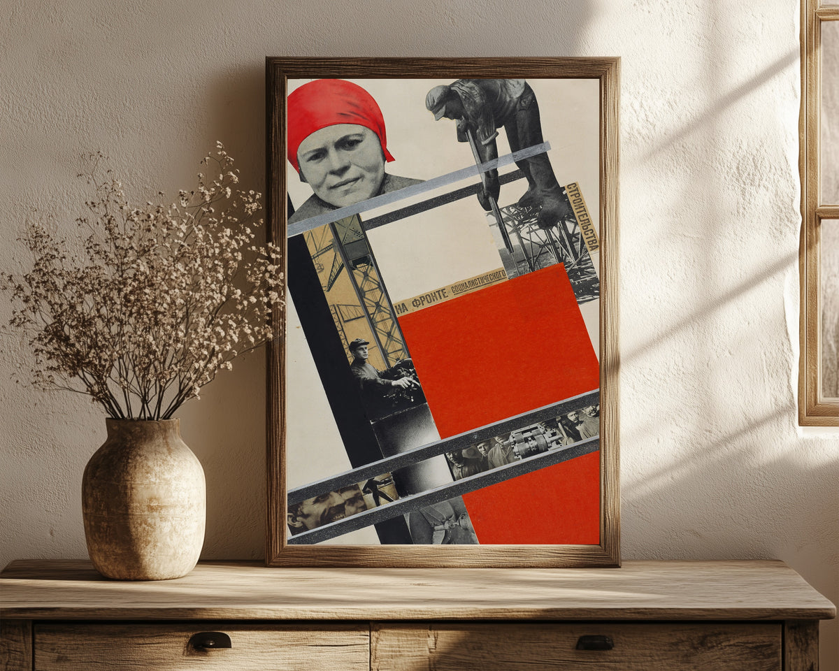 Framed art print of On the front of socialist construction by Gustav Klutsis, in a dark wood frame leaning on a rustic console beside dried flowers