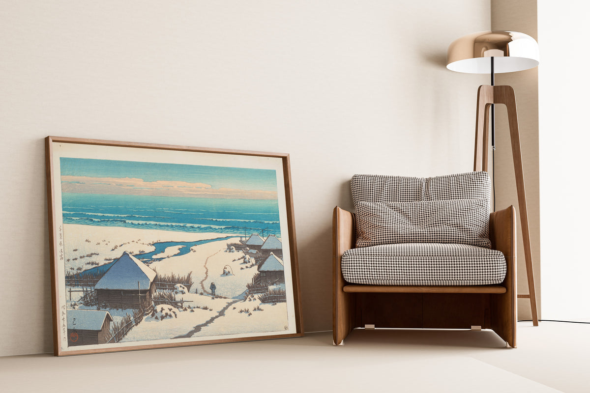Framed art print of Onjuku, Chiba Prefecture by Kawase Hasui, leaning against a wall beside an armchair and a floor lamp