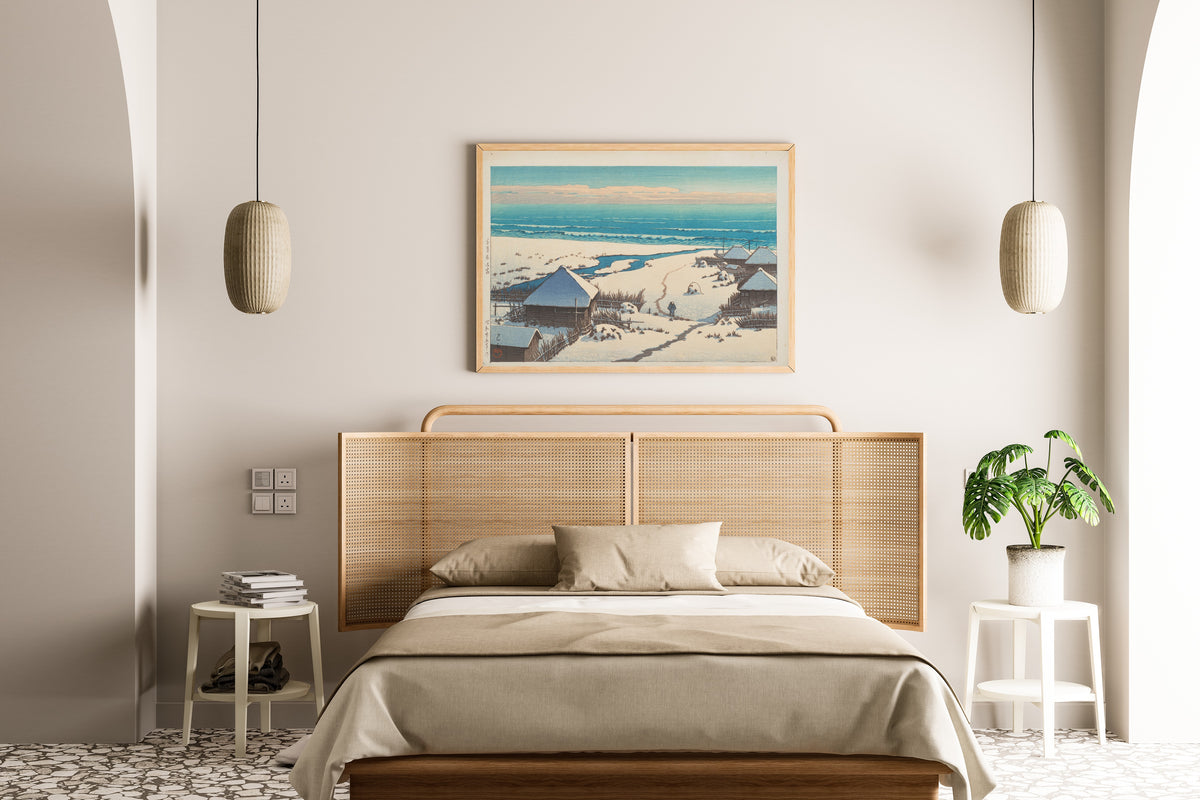 Framed art print of Onjuku, Chiba Prefecture by Kawase Hasui, above a cane-headboard bed