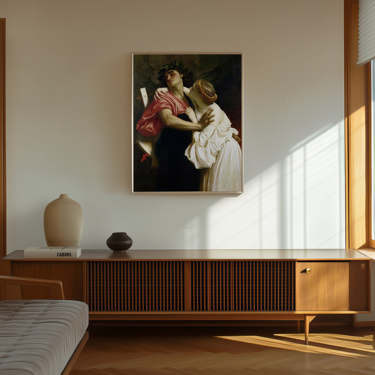 Framed art print of Orpheus and Eurydice by Frederic Leighton, in a thin light frame on a sunlit wall above a wooden sideboard