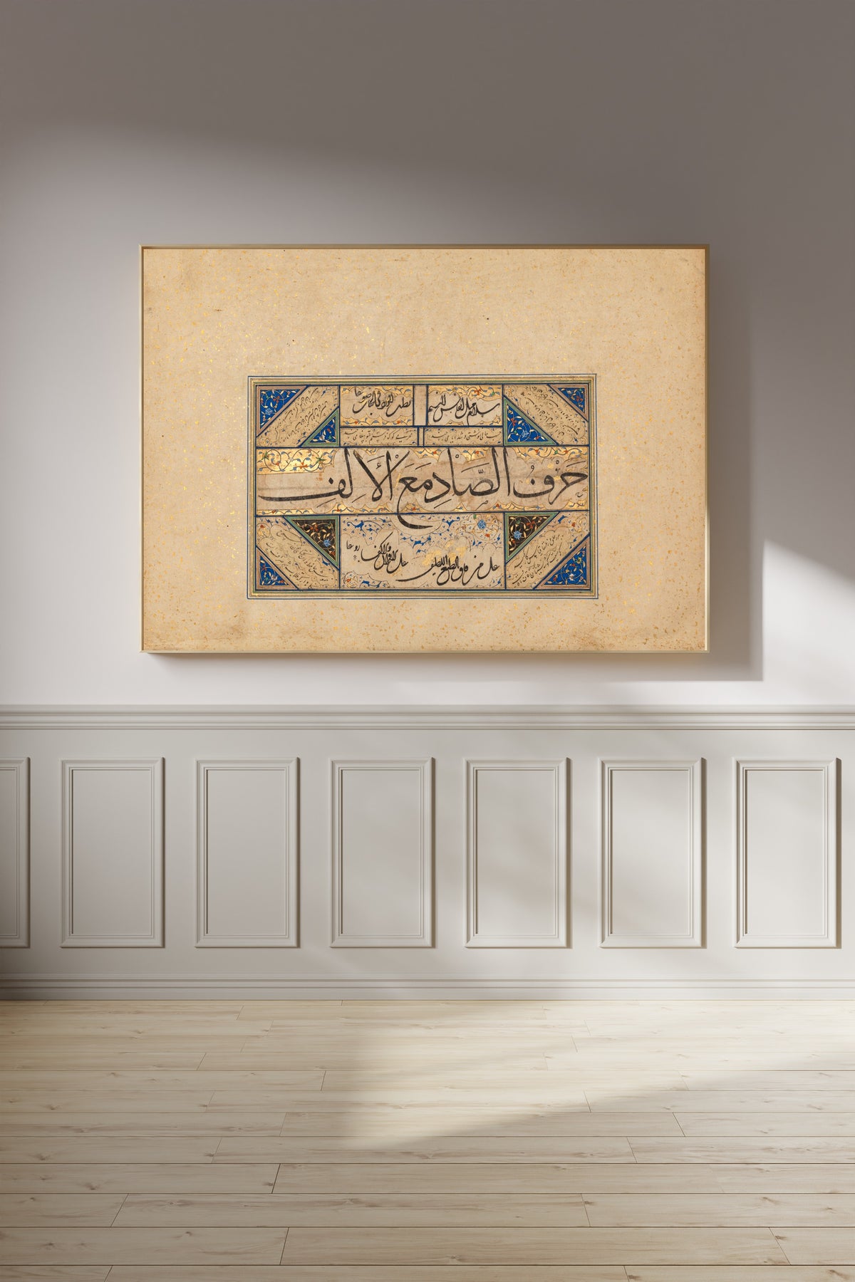 Framed art print of Page of Calligraphy by Sultan Muhammad Nur, on a panelled wall in afternoon light