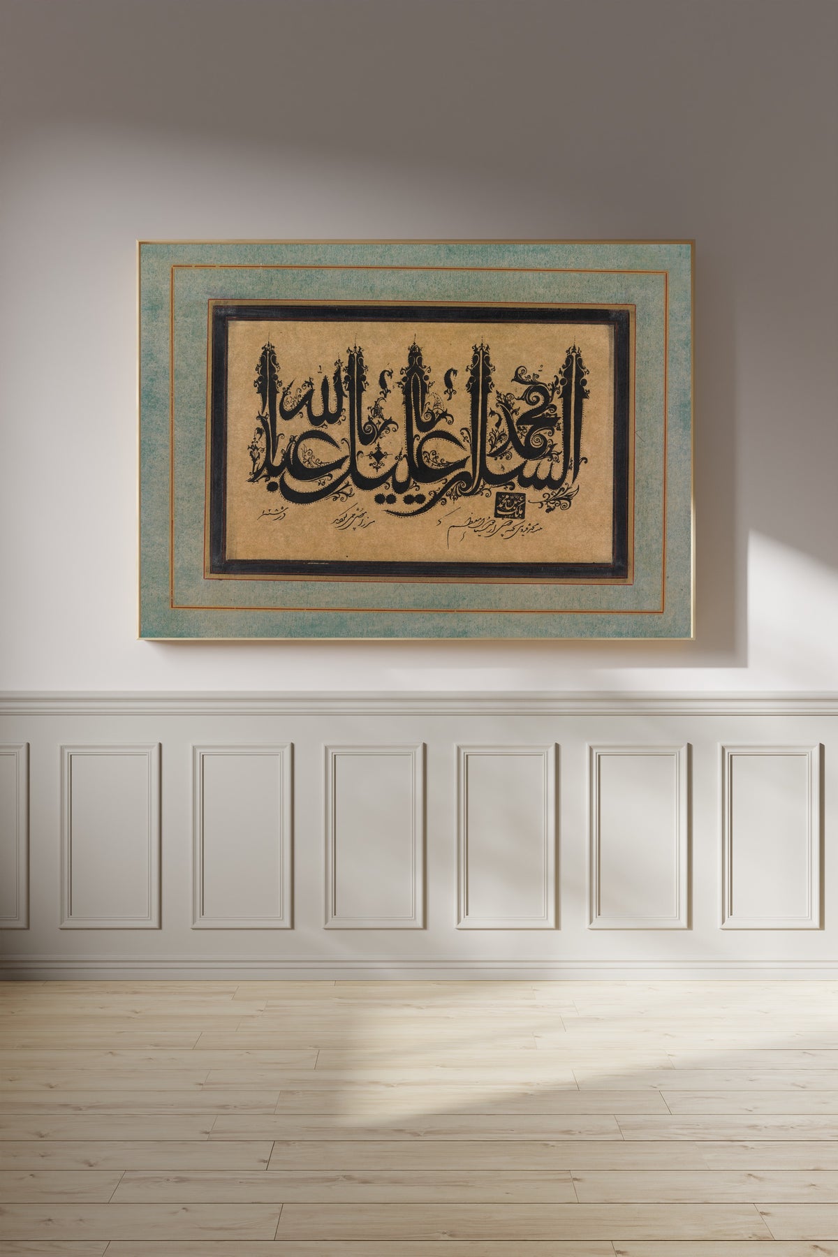Framed art print of Page of Calligraphy in Ornamental Style by Malik Muhammad Qazvini, on a panelled wall in afternoon light