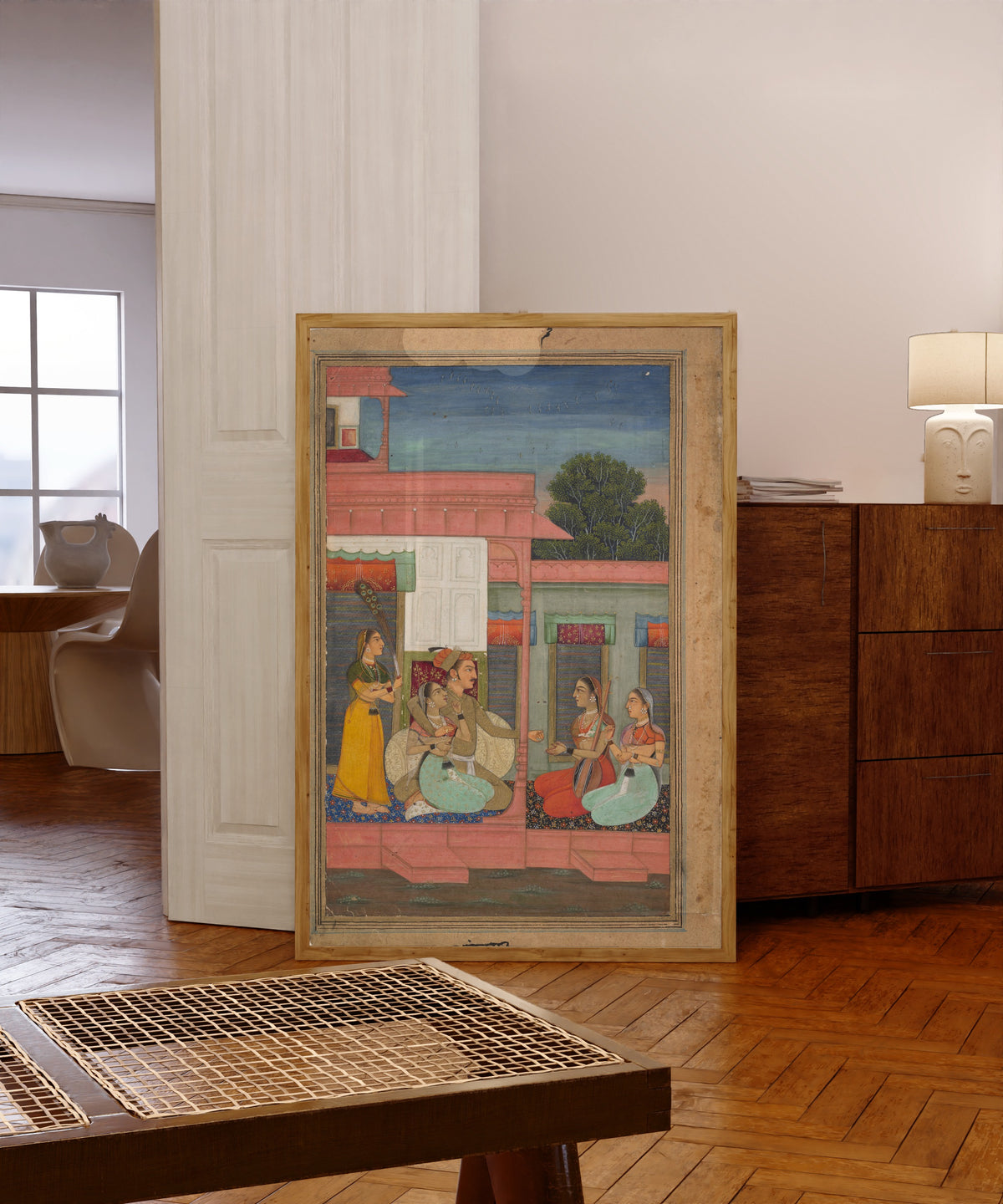 Framed art print of Panchama Ragini: Page from a Ragamala Series by Bikaner school, in a light wood frame leaning in a warm room with a parquet floor