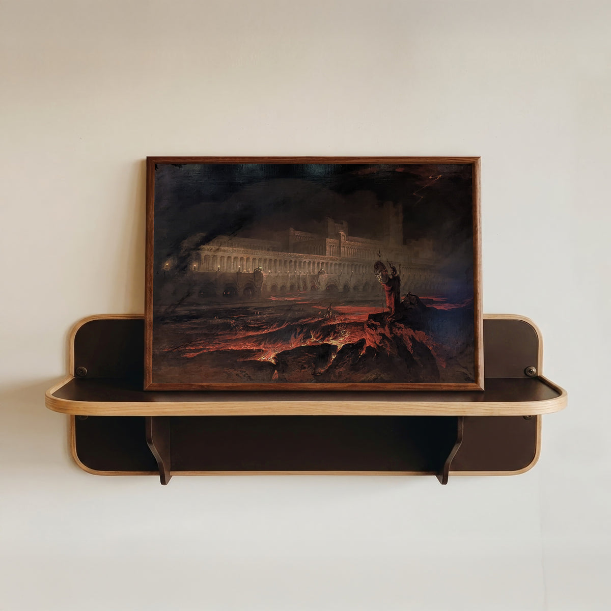 Framed art print of Pandemonium by John Martin, in a dark wood frame resting on a wall shelf