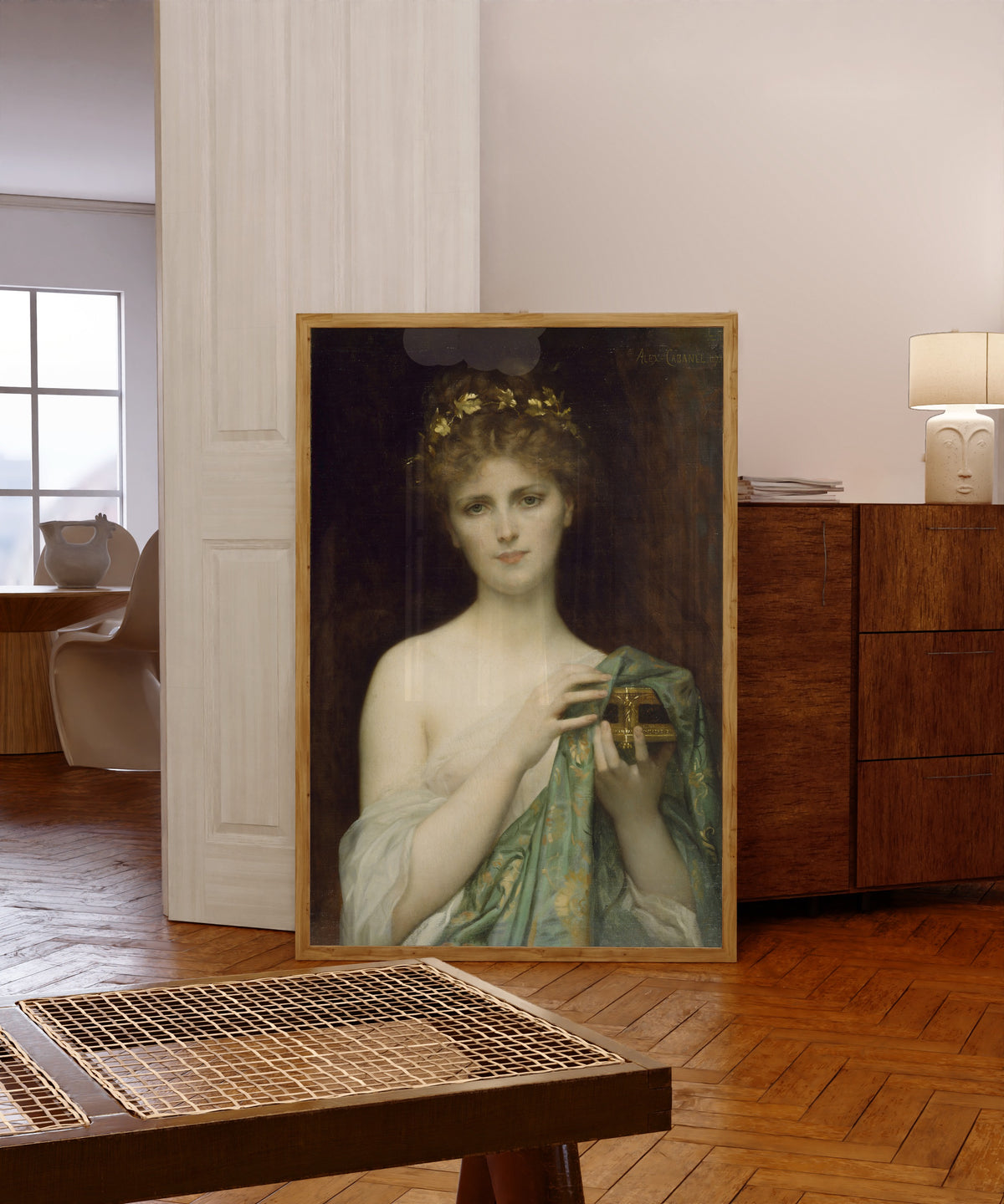 Framed art print of Pandora by Alexandre Cabanel, in a light wood frame leaning in a warm room with a parquet floor