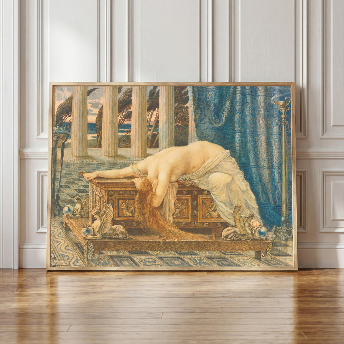 Framed art print of Pandora by Walter Crane, in a light wood frame leaning against a panelled white wall