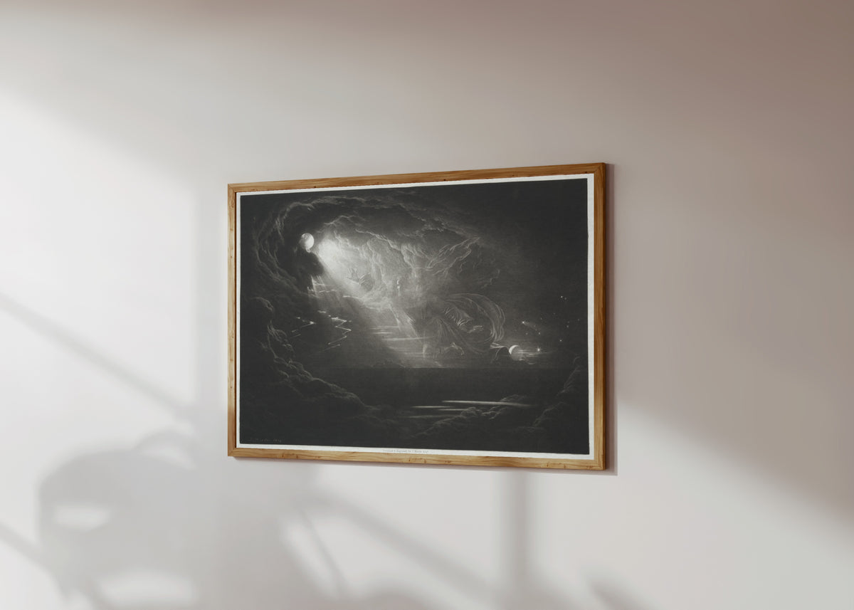 Framed art print of Paradise Lost: The Creation of Light by John Martin, in a light wood frame on a sunlit white wall, seen at a slight angle