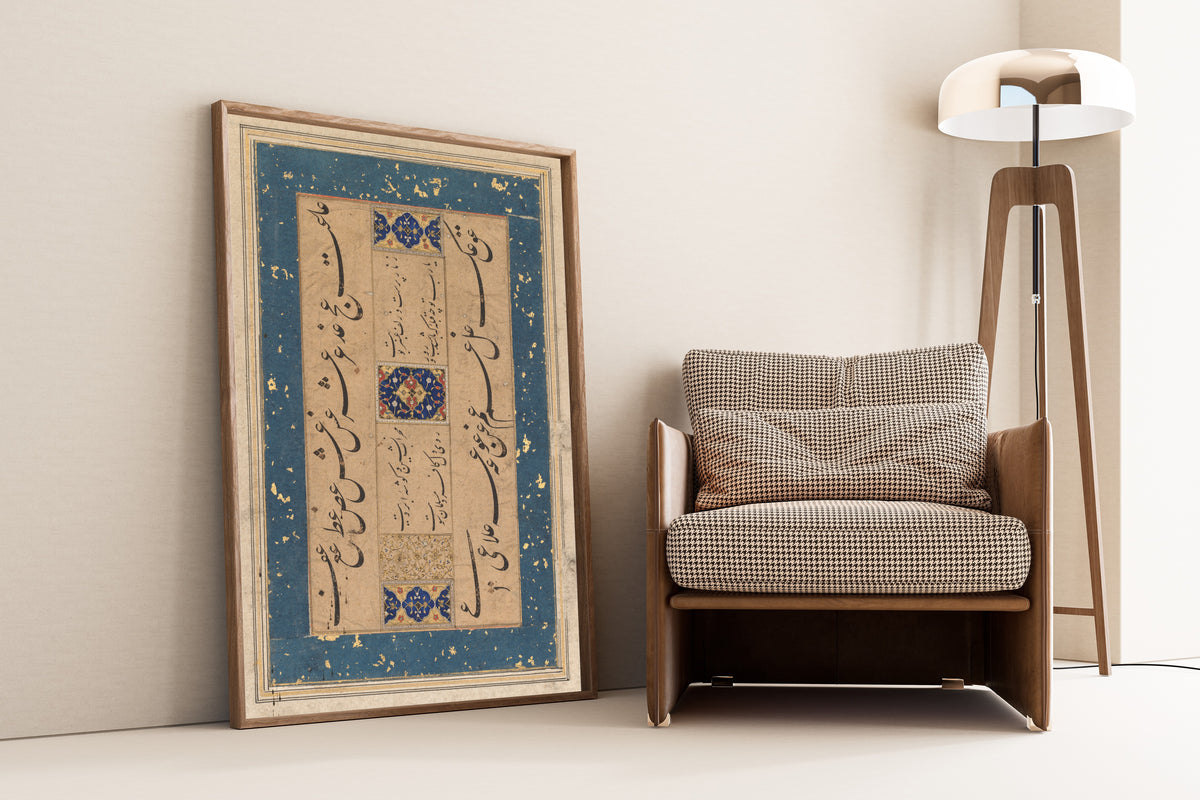 Framed art print of Persian Ruba'i (Quatrain) by Maulana Muhammad Murshidi Zawara'i, leaning against a wall beside an armchair and a floor lamp