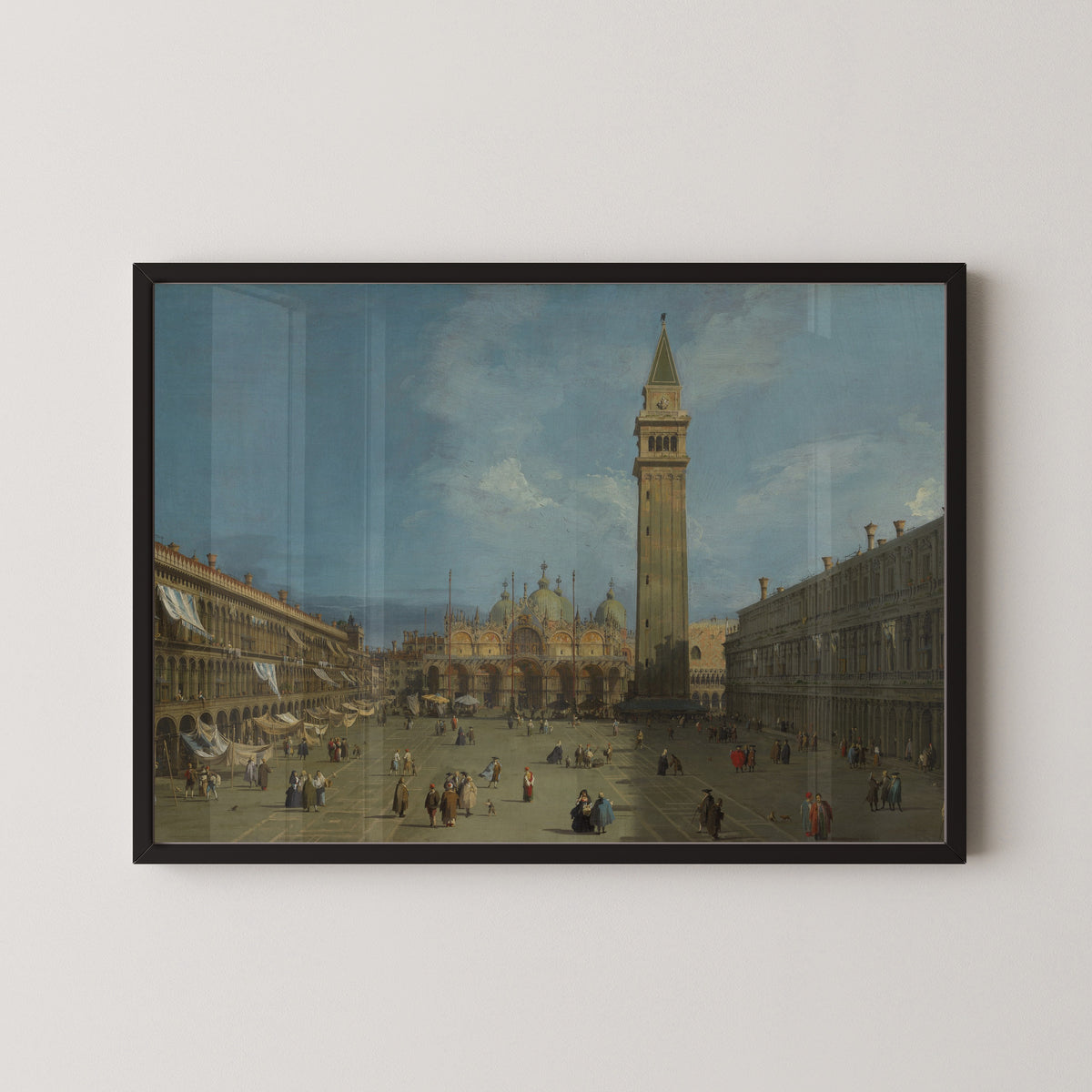 Framed art print of Piazza San Marco by Canaletto, in a black frame on a pale wall