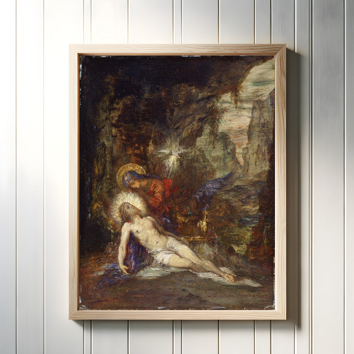 Framed art print of Pietà by Gustave Moreau, in a light wood frame on a white panelled wall