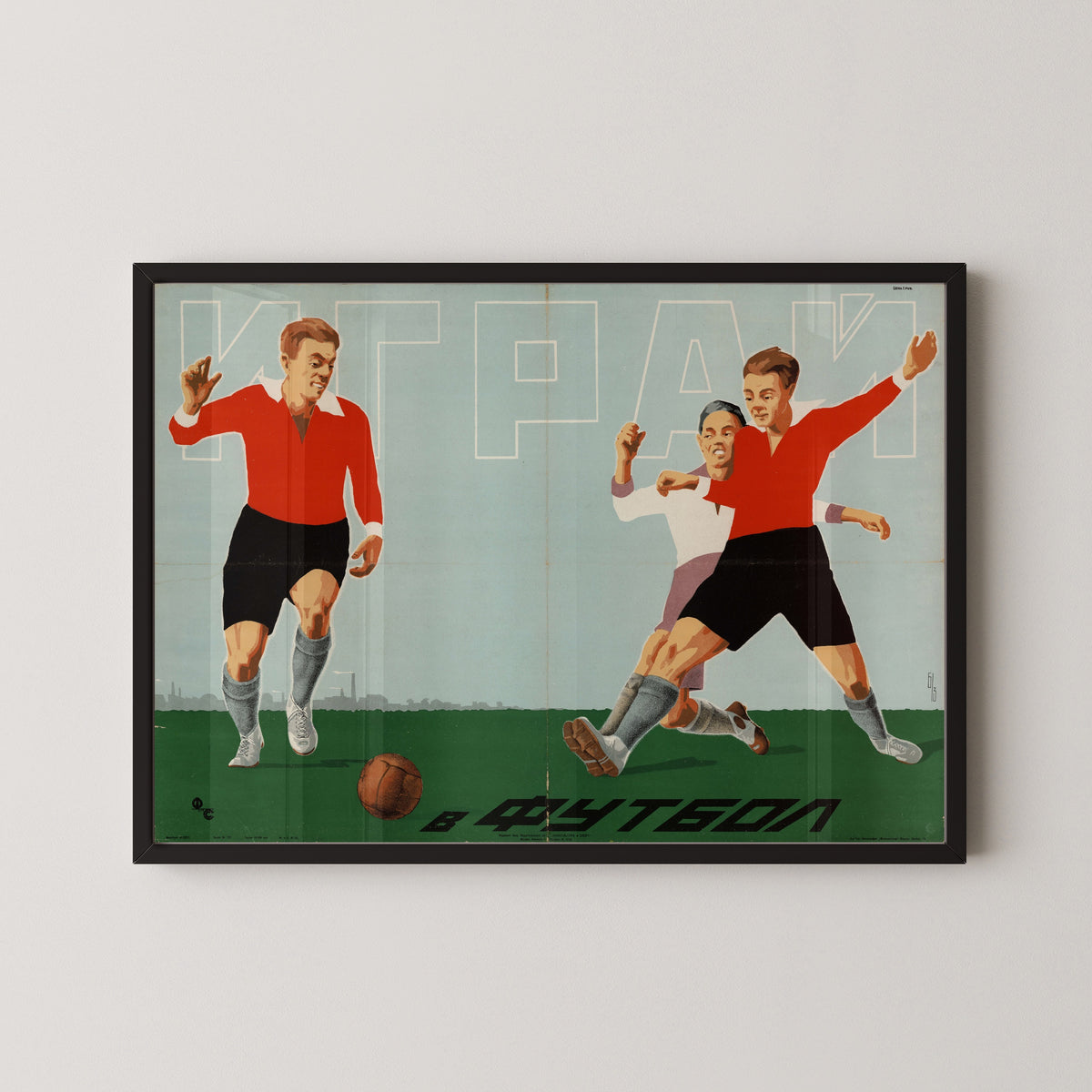 Framed art print of Play Football, in a black frame on a pale wall