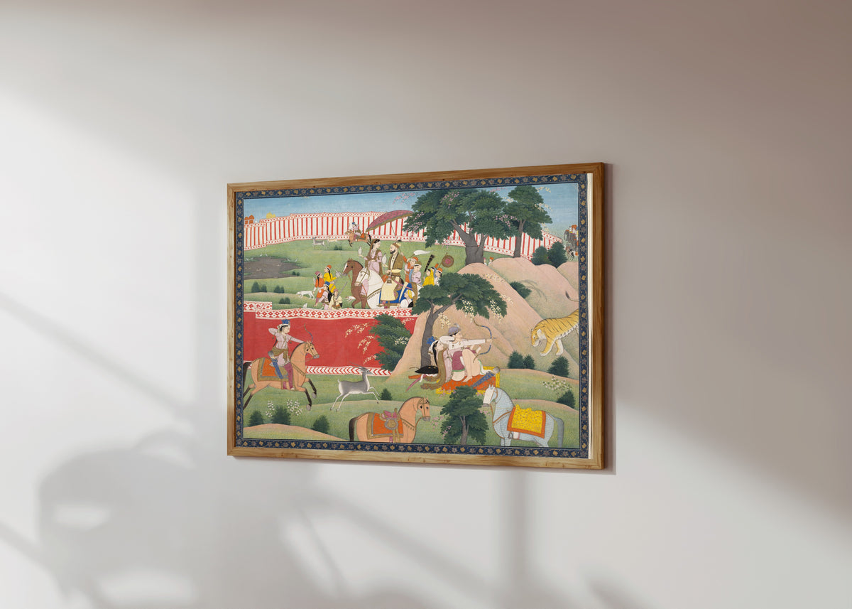 Framed art print of Pleasures of the Hunt by Kangra school, in a light wood frame on a sunlit white wall, seen at a slight angle