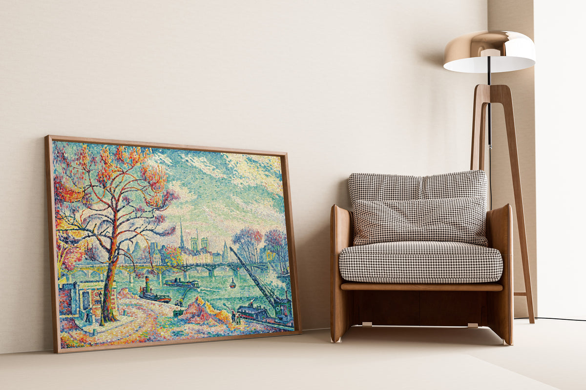Framed art print of Pont des Arts, Paris by Paul Signac, leaning against a wall beside an armchair and a floor lamp