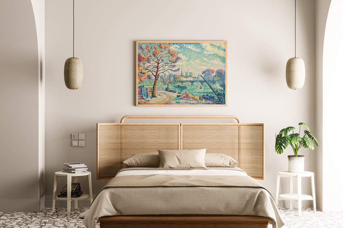 Framed art print of Pont des Arts, Paris by Paul Signac, above a cane-headboard bed