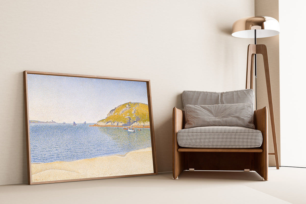 Framed art print of Port of Saint-Cast by Paul Signac, leaning against a wall beside an armchair and a floor lamp