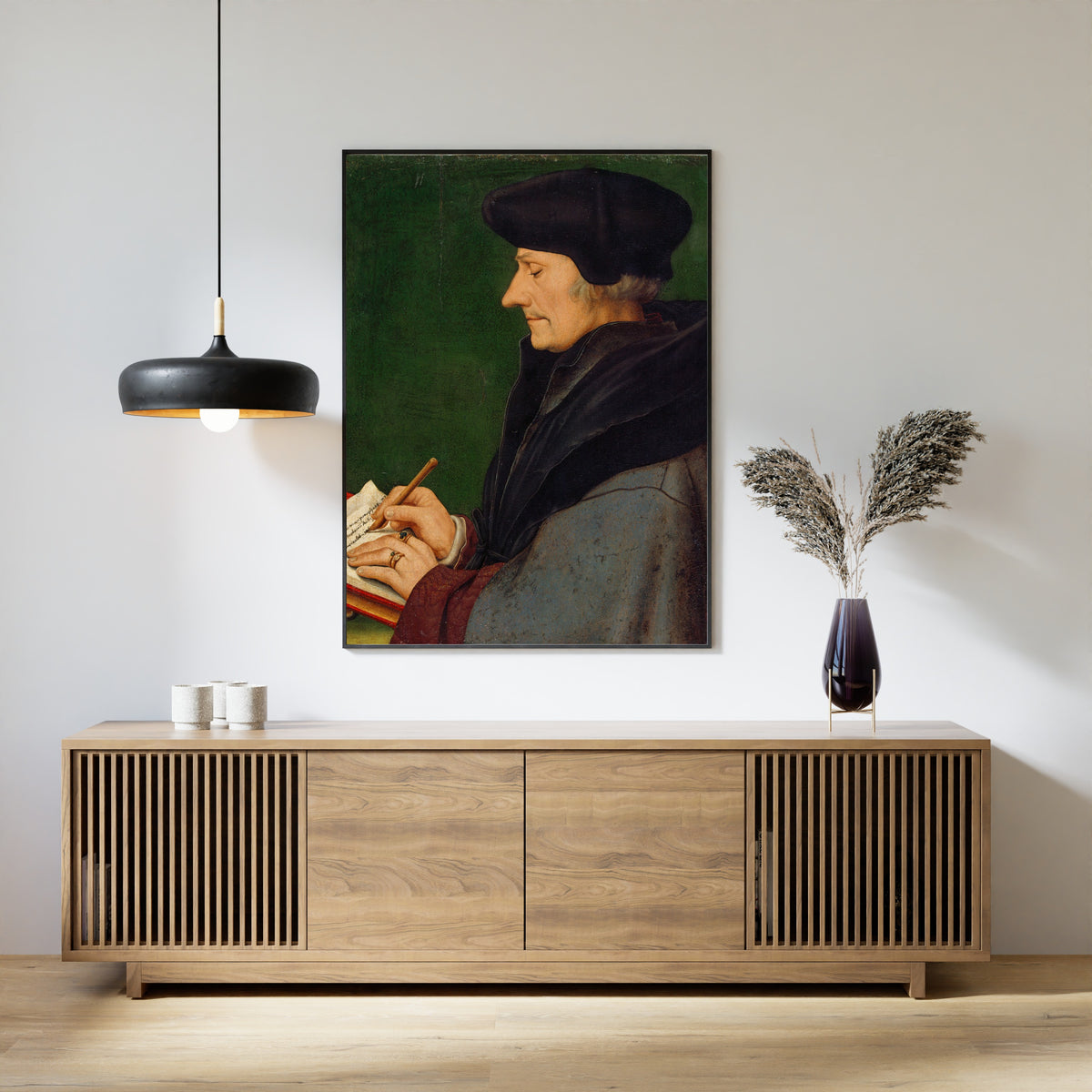Framed art print of Portrait of Erasmus of Rotterdam Writing by Hans Holbein the Younger, above a slatted wood sideboard