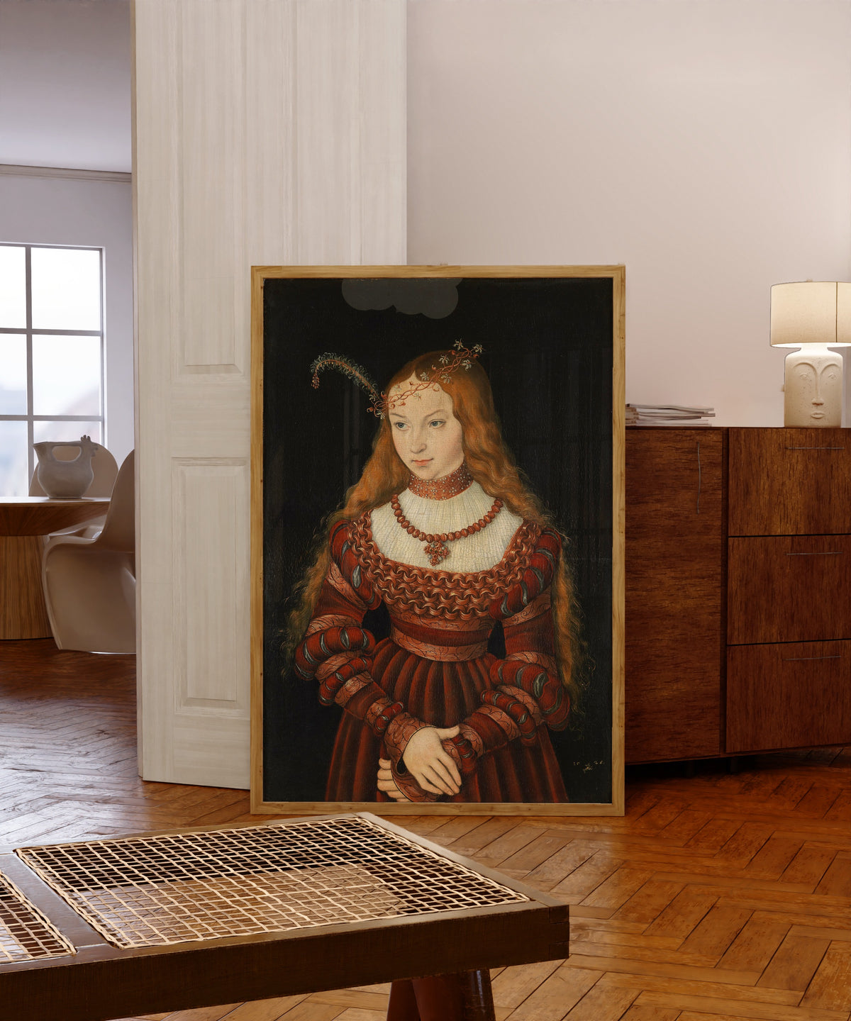 Framed art print of Portrait of Princess Sibylle of Cleves by Lucas Cranach the Elder, in a light wood frame leaning in a warm room with a parquet floor