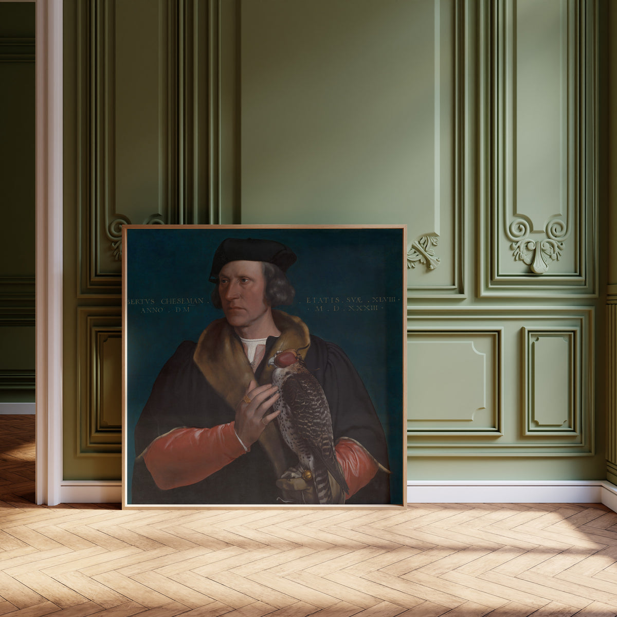 Framed art print of Portrait of Robert Cheseman by Hans Holbein the Younger, leaning against olive-green panelling on a herringbone floor