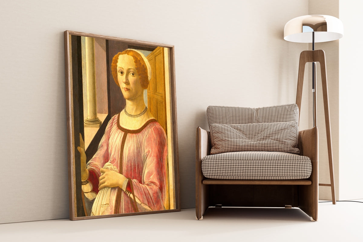 Framed art print of Portrait of Smeralda Bandinelli by Sandro Botticelli, leaning against a wall beside an armchair and a floor lamp