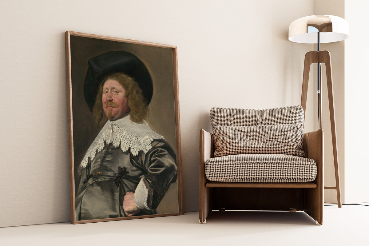 Framed art print of Portrait of a Man, Possibly Nicolaes Pietersz Duyst van Voorhout by Frans Hals, leaning against a wall beside an armchair and a floor lamp