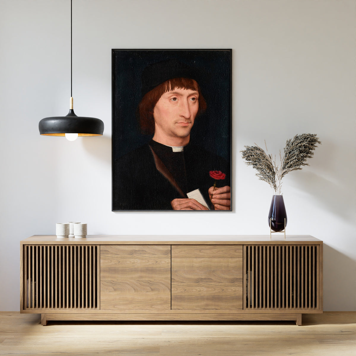Framed art print of Portrait of a Man with a Pink by Hans Memling, above a slatted wood sideboard