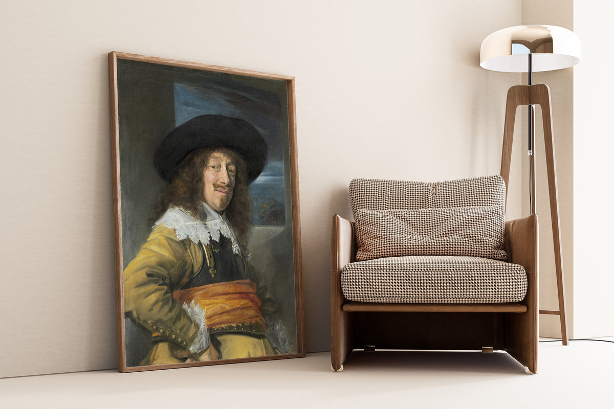 Framed art print of Portrait of a Member of the Haarlem Civic Guard by Frans Hals, leaning against a wall beside an armchair and a floor lamp