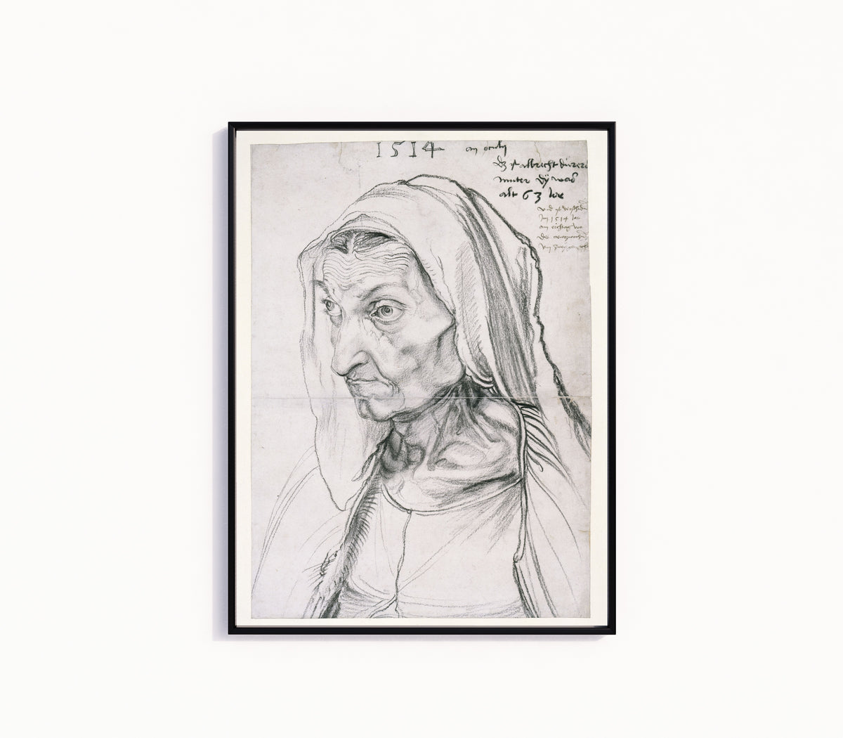 Framed art print of Portrait of the Artist's Mother at the Age of 63 by Albrecht Dürer, in a slim black frame on a plain white wall