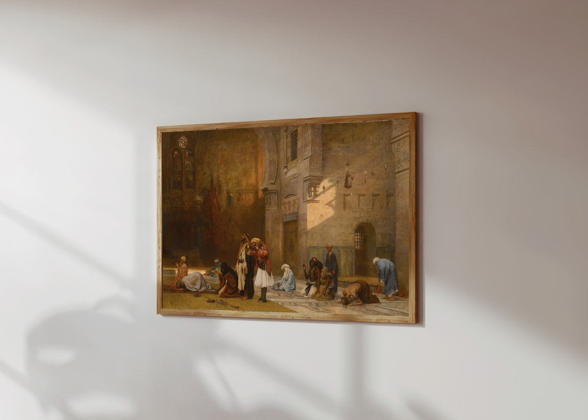 Framed art print of Prayer in the Mosque, Cairo by Frederick Arthur Bridgman, in a light wood frame on a sunlit white wall, seen at a slight angle