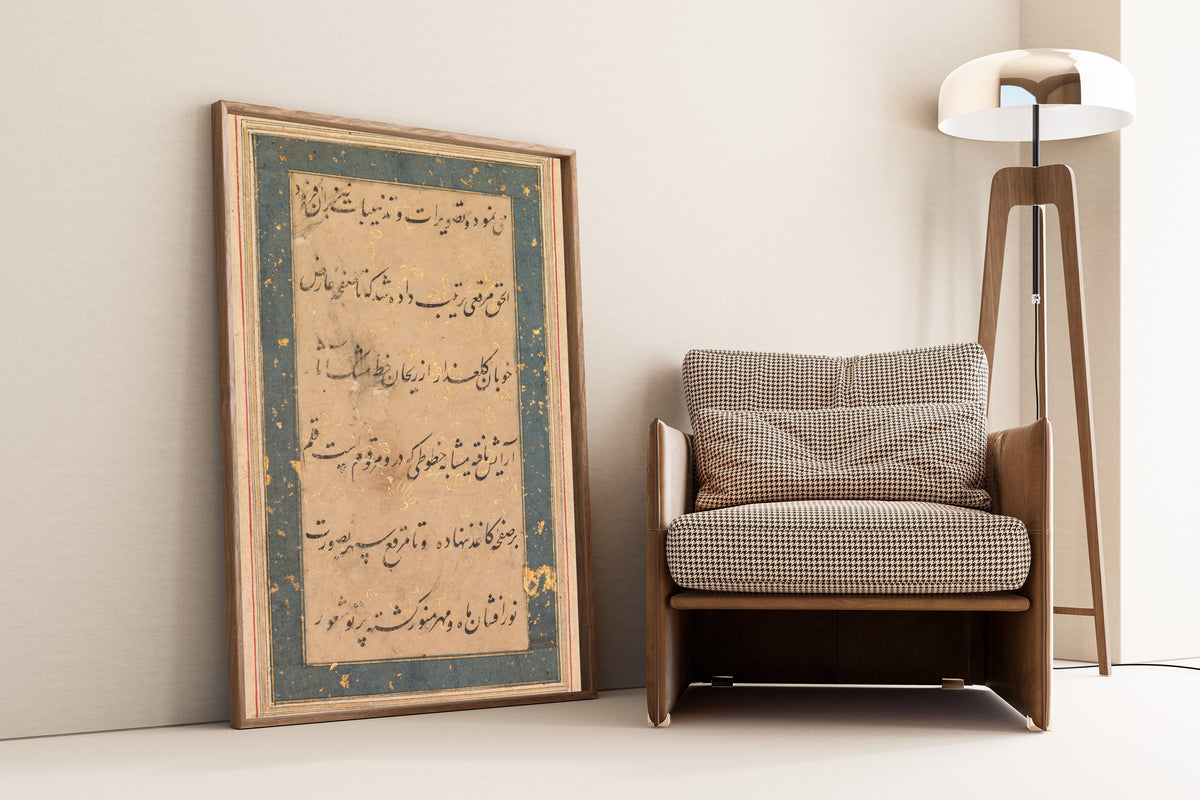 Framed art print of Preface to the Anvar-i Suhaili, leaning against a wall beside an armchair and a floor lamp