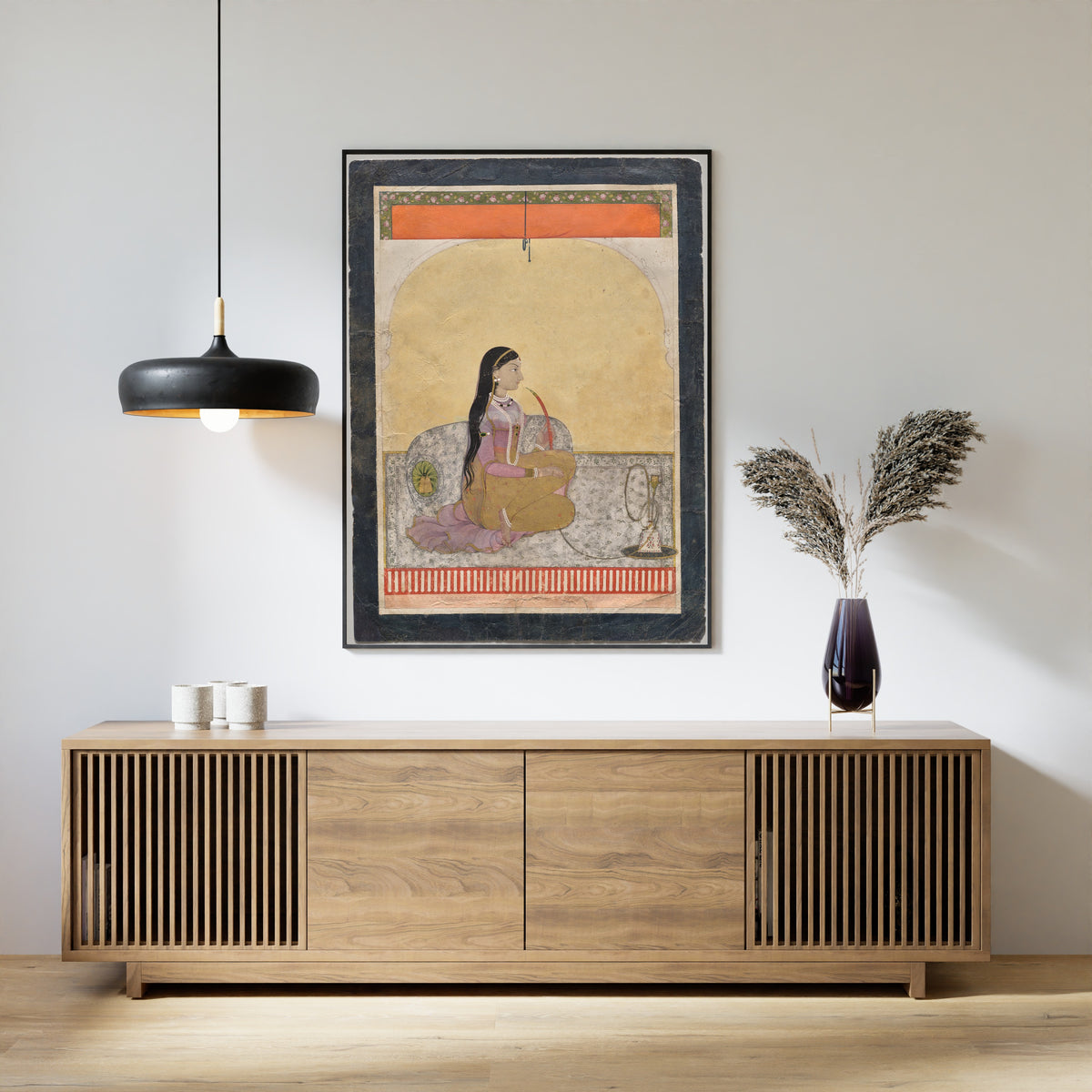 Framed art print of Princess Smoking a Hookah by Pahari school, above a slatted wood sideboard