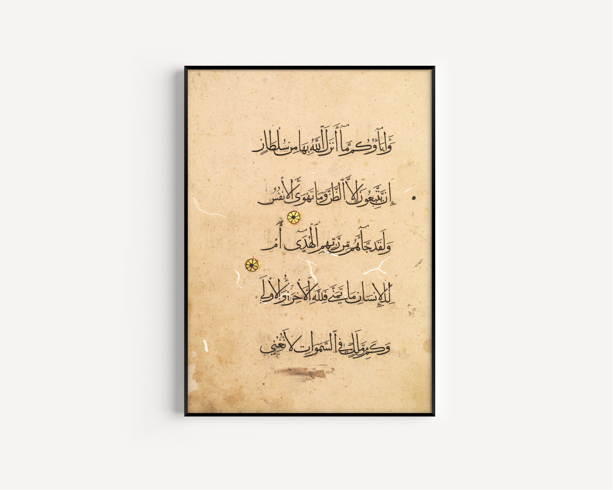 Framed art print of Qur'an Folio: Sura al-Najm (Left Page), in a slim black frame on a plain white wall
