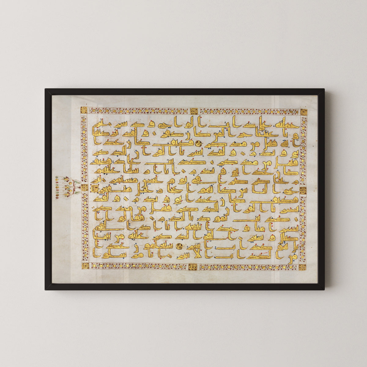 Framed art print of Qur'an Folio: Sura al-Qamar, in a black frame on a pale wall