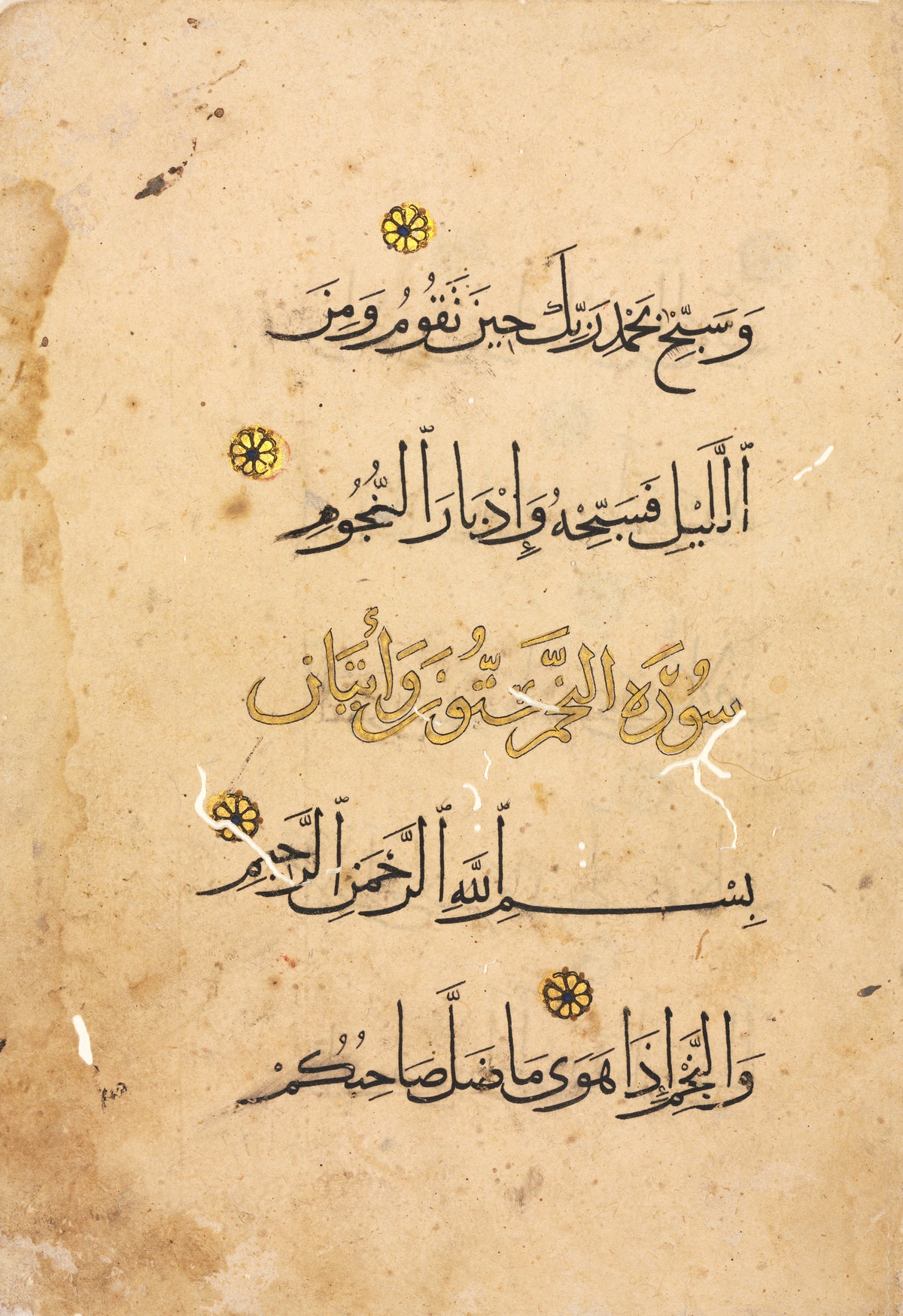 Qur'an Folio: Suras al-Tur and al-Najm — A gold heading line among broad black script on buff paper