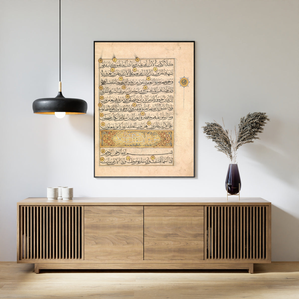 Framed art print of Qur'an Folio (Illuminated Sura Heading), above a slatted wood sideboard